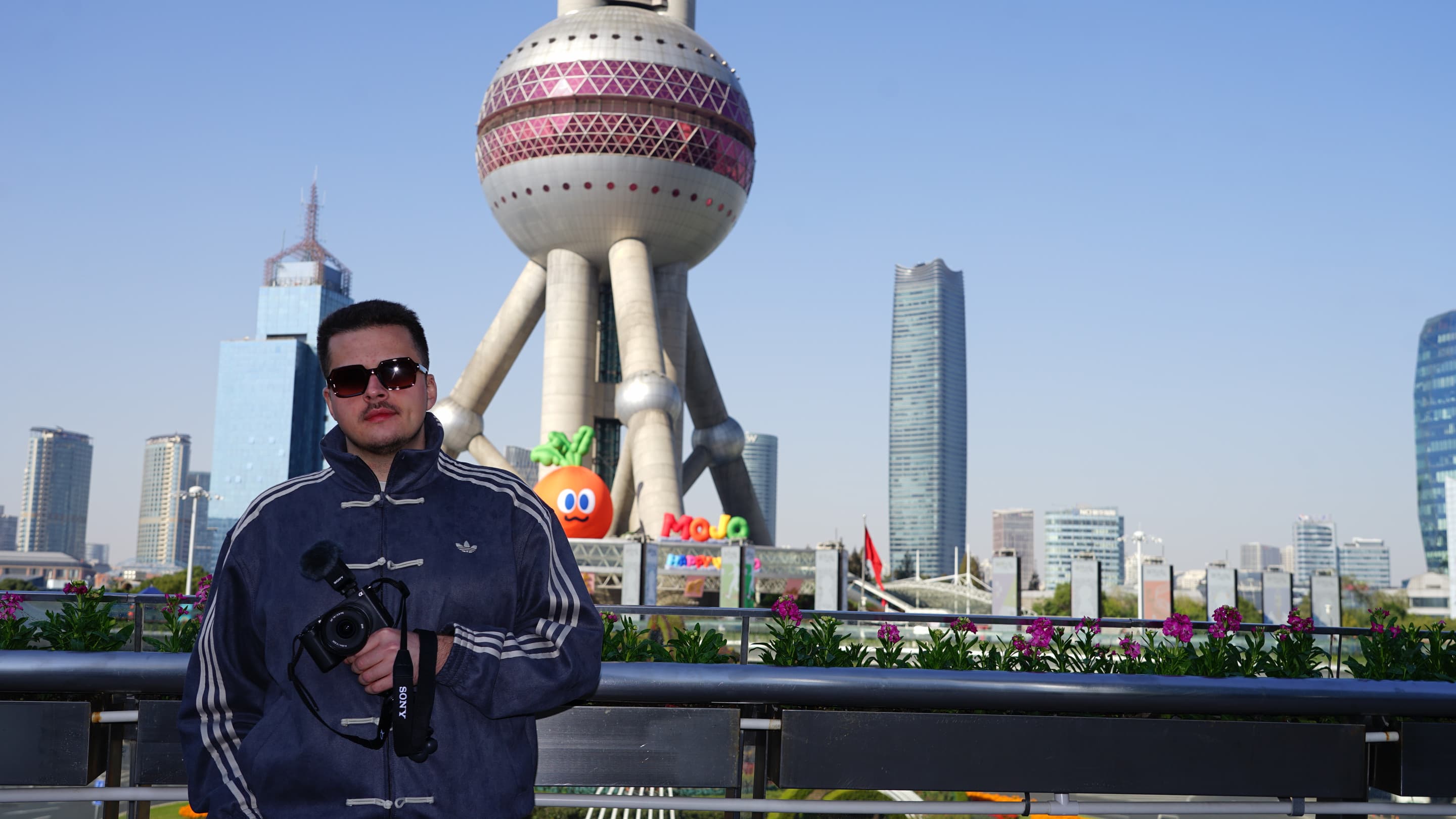 Bartosz z aparatem na tle Oriental Pearl Tower w Szanghaju